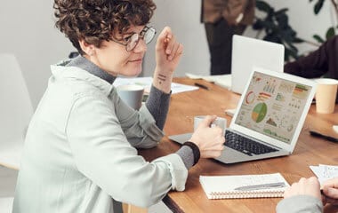 woman sitting at computer with mug